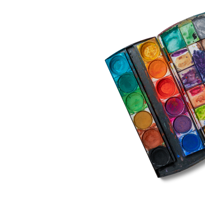 A partially open watercolor palette belonging to a trauma psychologist, featuring multiple circular paint wells in various colors, some visibly used, set against a white background.